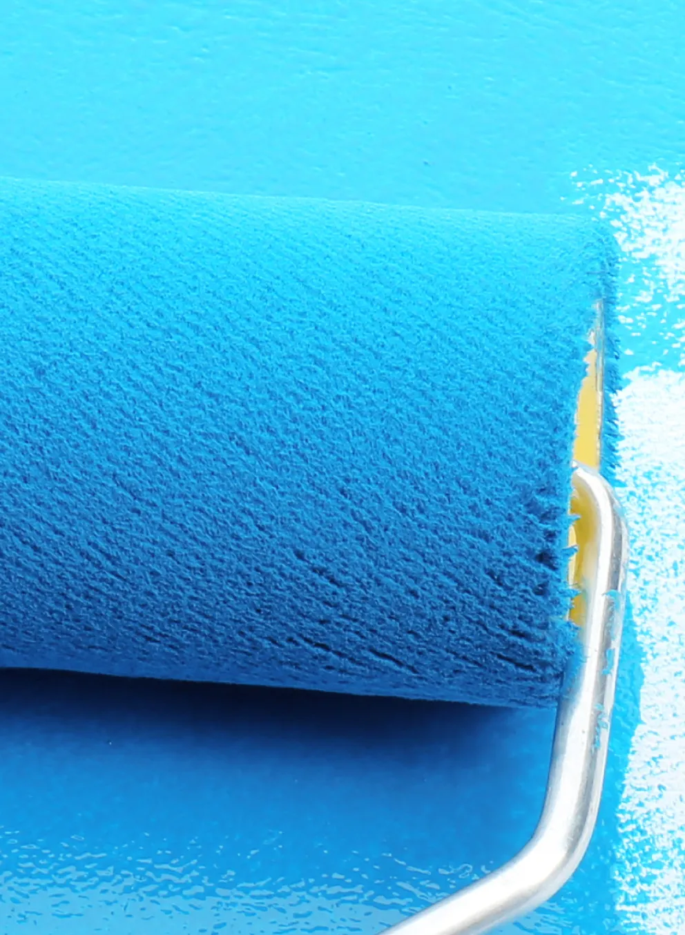 paint roller painting blue paint on a wall