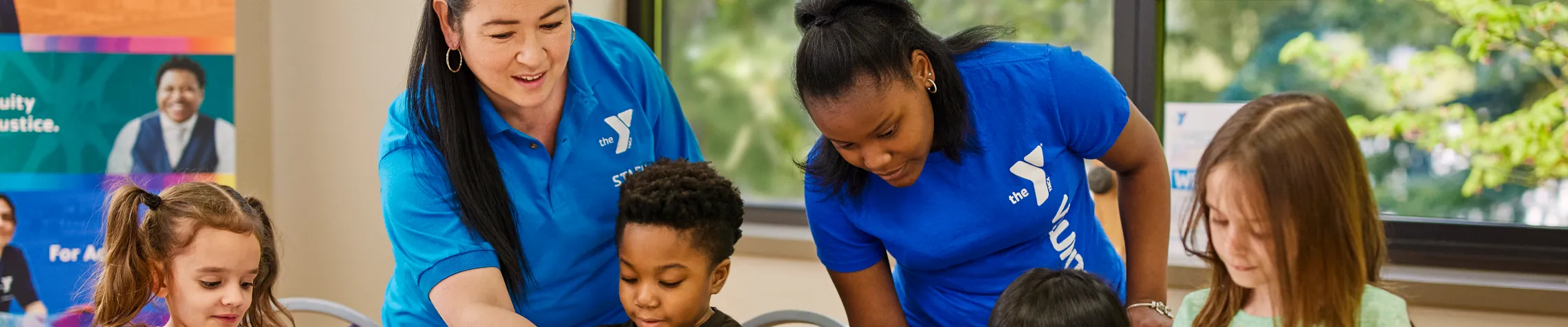 Y Child Watch Staff help children with a project